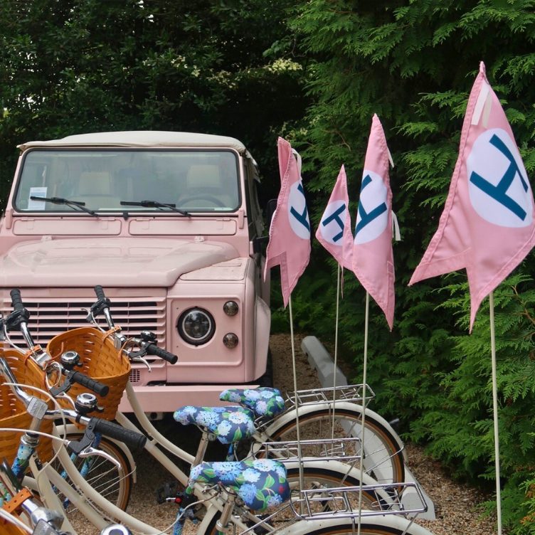 Pink Land Rover and bicycles with East Hampton flags